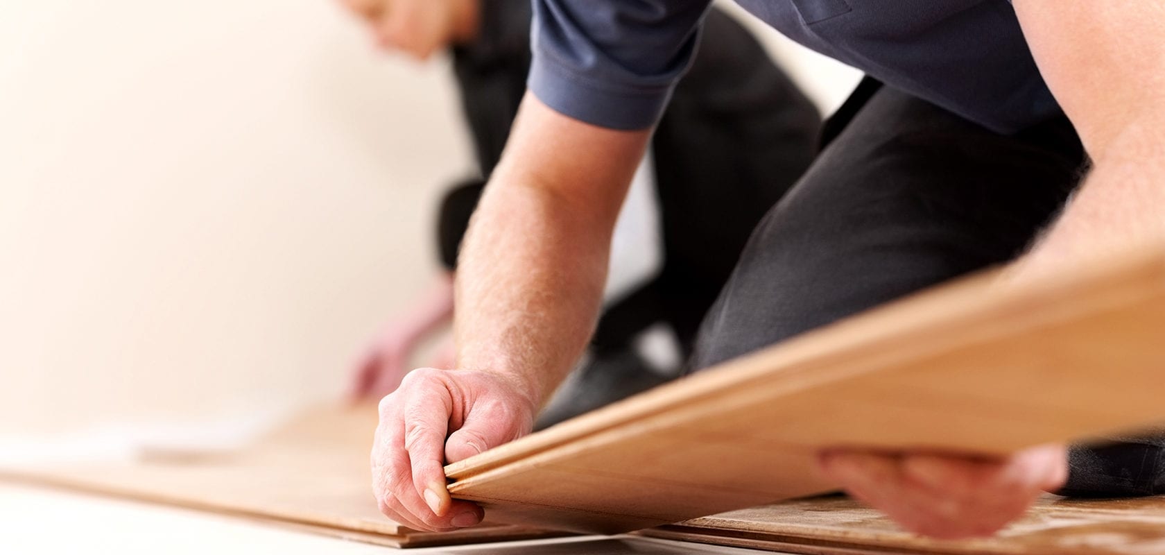 close up view of people installing laminate flooring