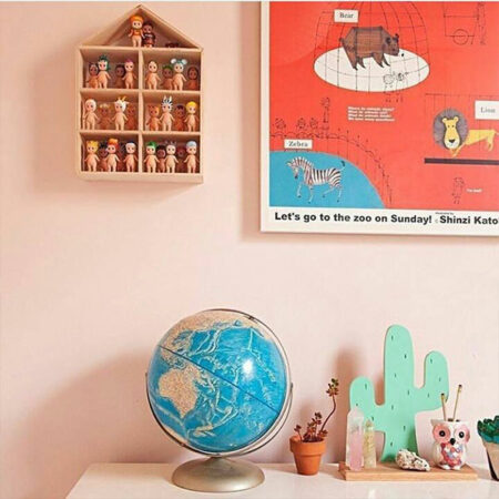 kids room with globe, doll display and cactus ornaments with wall painted in mellow pink